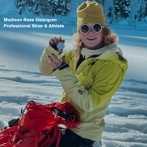 Madison Rose holding Dermatone Z-cote tin in the snow with her red backpack