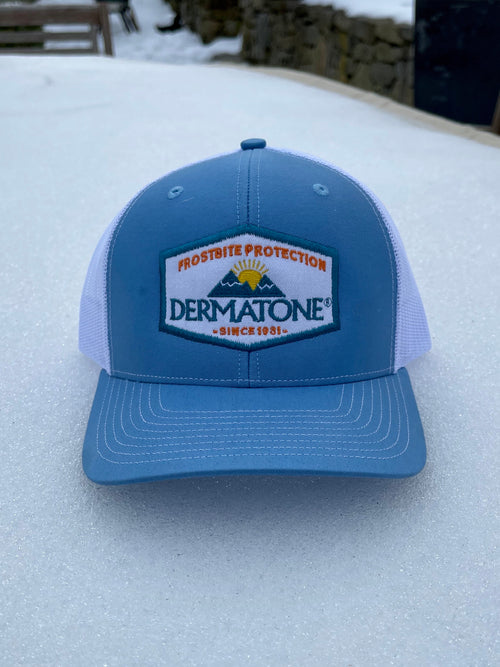 Dermatone Retro Trucker Hat - Sky Blue/White sitting on snow